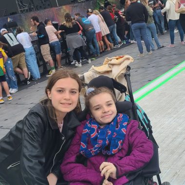 coldplay tour 2022 | Rett Syndrome News | Cammy and her sister, Ryan, pose by the stage before a Coldplay concert in Chicago